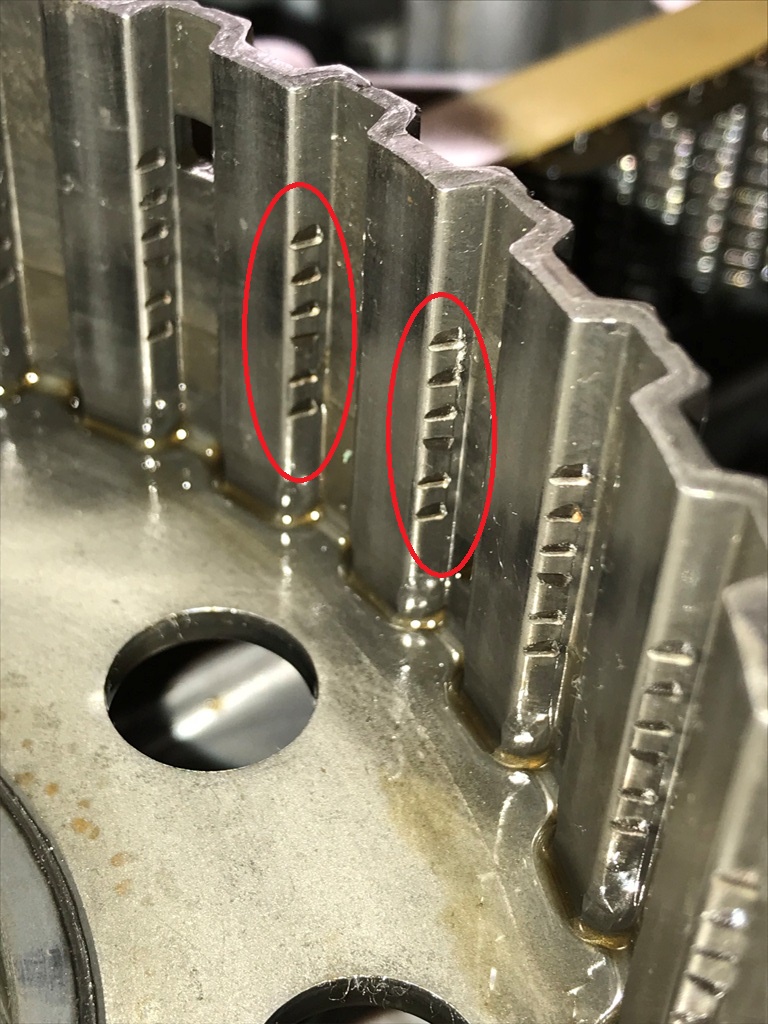 Close-up of worn gear teeth marked for replacement